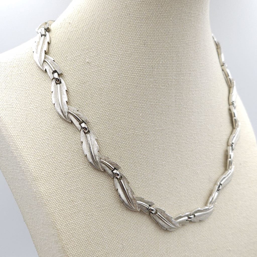 Collana firmata Trifari risalente ai primissimi anni '60, con decoro di foglie in lega Trifanium color argento satinato con venature lucide - VINTAGE AMORE MIO Collana firmata Trifari risalente ai primissimi anni '60, con decoro di foglie in lega Trifanium color argento satinato con venature lucide - VINTAGE AMORE MIO