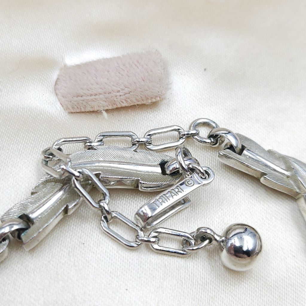 Collana firmata Trifari risalente ai primissimi anni '60, con decoro di foglie in lega Trifanium color argento satinato con venature lucide - VINTAGE AMORE MIO Collana firmata Trifari risalente ai primissimi anni '60, con decoro di foglie in lega Trifanium color argento satinato con venature lucide - VINTAGE AMORE MIO