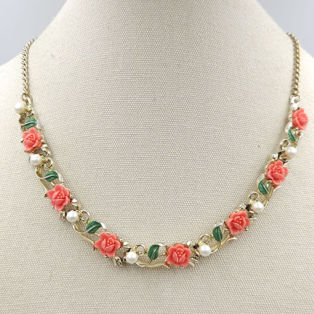 Full parure anni '50, composta da collana, braccialetto, spilla e orecchini a clip, in metallo color oro con decoro di roselline di lucite color corallo, smalto verde e perle - VINTAGE AMORE MIO