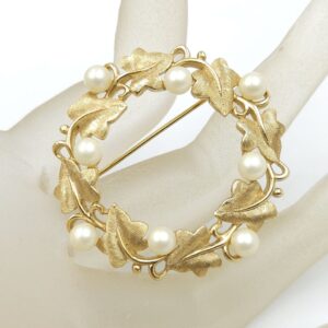 Spilla realizzata da Trifari intorno al 1960, a forma di ghirlanda, con squisite foglioline in lega Trifanium color oro satinato e perle, dettagli in lega Trifanium color oro lucido - VINTAGE AMORE MIO