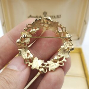 Spilla realizzata da Trifari intorno al 1960, a forma di ghirlanda, con squisite foglioline in lega Trifanium color oro satinato e perle, dettagli in lega Trifanium color oro lucido - VINTAGE AMORE MIO