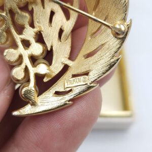 Spilla Trifari risalente al 1960 circa, decoro botanico, realizzata in lega Trifanium color oro satinato con particolari lucidi e perle - VINTAGE AMORE MIO