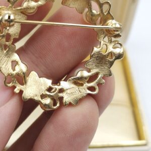 Spilla realizzata da Trifari intorno al 1960, a forma di ghirlanda, con squisite foglioline in lega Trifanium color oro satinato e perle, dettagli in lega Trifanium color oro lucido - VINTAGE AMORE MIO