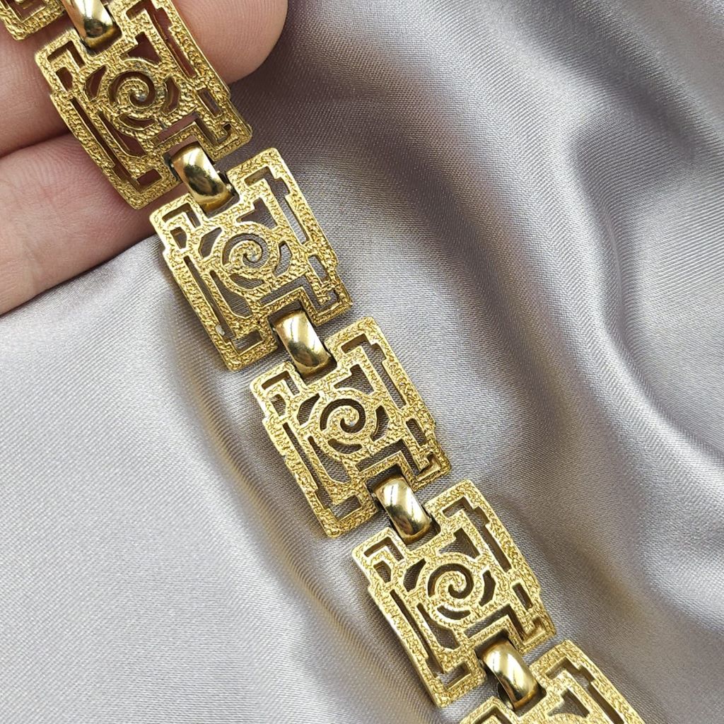 Braccialetto Trifari risalente al 1960 circa con decoro geometrico, realizzato in lega Trifanium color oro con lavorazione a cera persa e dettagli lucidi - VINTAGE AMORE MIO Braccialetto Trifari risalente al 1960 circa con decoro geometrico, realizzato in lega Trifanium color oro con lavorazione a cera persa e dettagli lucidi - VINTAGE AMORE MIO