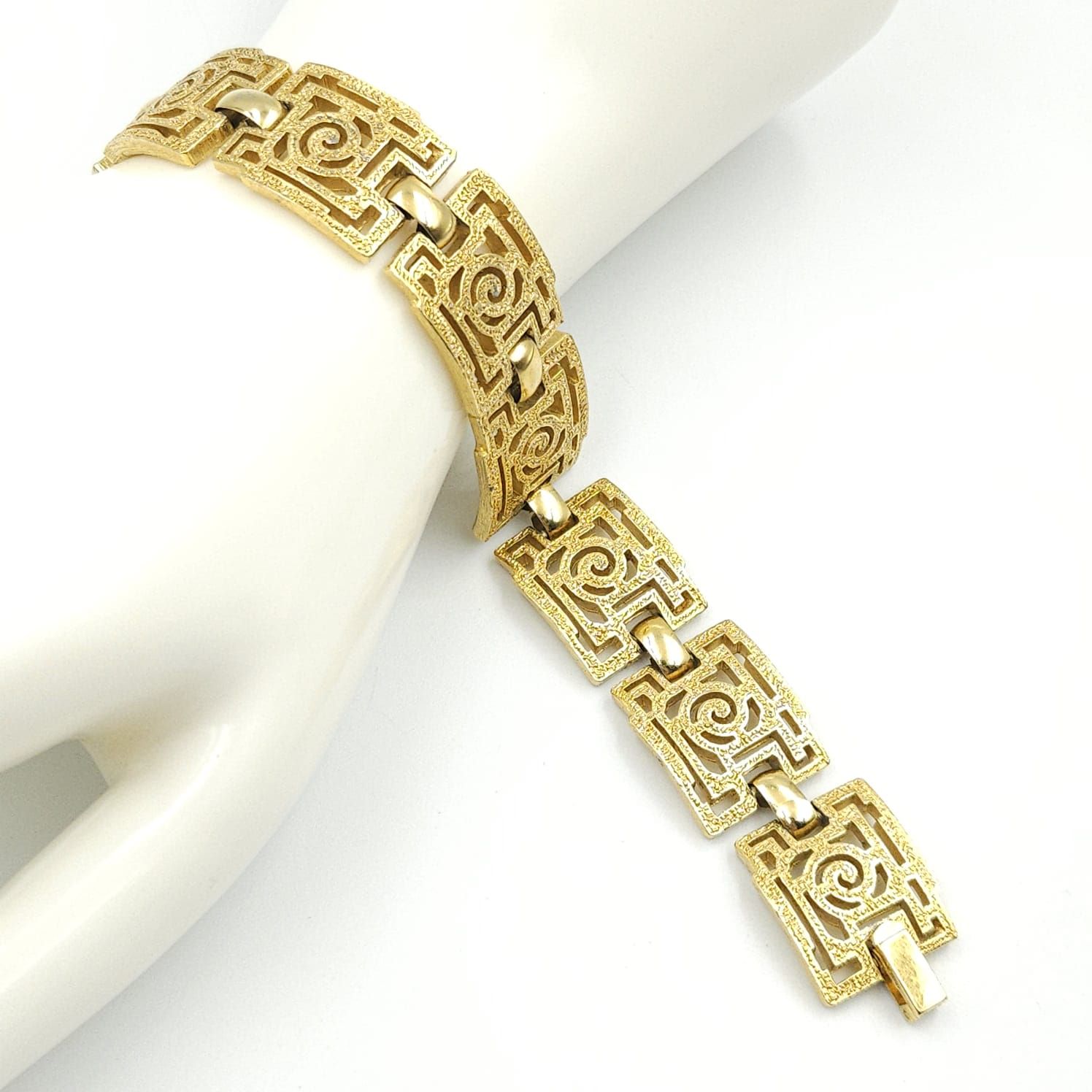 Braccialetto Trifari risalente al 1960 circa con decoro geometrico, realizzato in lega Trifanium color oro con lavorazione a cera persa e dettagli lucidi - VINTAGE AMORE MIO Braccialetto Trifari risalente al 1960 circa con decoro geometrico, realizzato in lega Trifanium color oro con lavorazione a cera persa e dettagli lucidi - VINTAGE AMORE MIO