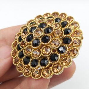 Spilla a cupola firmata Lisner, risalente al 1960 circa, realizzata in metallo color oro con lavorazione a cordoncino e cristalli color nero e topazio - VINTAGE AMORE MIO