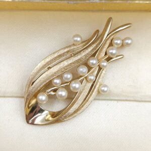 Spilla firmata Trifari risalente alla seconda metà degli anni cinquanta, realizzata in lega Trifanium color oro satinato con dettagli lucidi e perle - VINTAGE AMORE MIO Spilla firmata Trifari risalente alla seconda metà degli anni cinquanta, realizzata in lega Trifanium color oro satinato con dettagli lucidi e perle - VINTAGE AMORE MIO