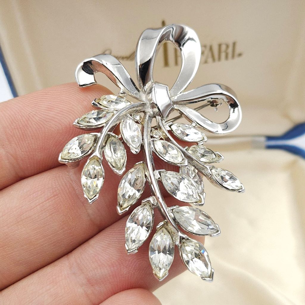Spilla Trifari anni '50 a forma di raffinato fiocco in lega Trifanium color platino, con cristalli diamante taglio navette - VINTAGE AMORE MIO Spilla Trifari anni '50 a forma di raffinato fiocco in lega Trifanium color platino, con cristalli diamante taglio navette - VINTAGE AMORE MIO