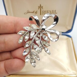 Spilla Trifari anni '50 a forma di raffinato fiocco in lega Trifanium color platino, con cristalli diamante taglio navette - VINTAGE AMORE MIO Spilla Trifari anni '50 a forma di raffinato fiocco in lega Trifanium color platino, con cristalli diamante taglio navette - VINTAGE AMORE MIO