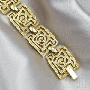 Braccialetto Trifari risalente al 1960 circa con decoro geometrico, realizzato in lega Trifanium color oro con lavorazione a cera persa e dettagli lucidi - VINTAGE AMORE MIO Braccialetto Trifari risalente al 1960 circa con decoro geometrico, realizzato in lega Trifanium color oro con lavorazione a cera persa e dettagli lucidi - VINTAGE AMORE MIO