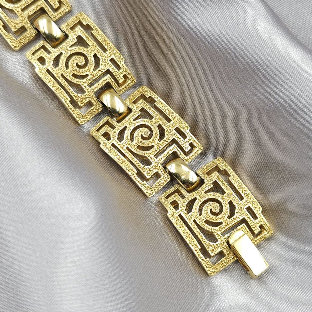 Braccialetto Trifari risalente al 1960 circa con decoro geometrico, realizzato in lega Trifanium color oro con lavorazione a cera persa e dettagli lucidi - VINTAGE AMORE MIO Braccialetto Trifari risalente al 1960 circa con decoro geometrico, realizzato in lega Trifanium color oro con lavorazione a cera persa e dettagli lucidi - VINTAGE AMORE MIO