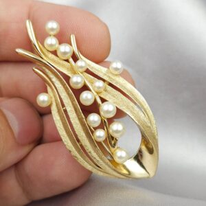 Spilla firmata Trifari risalente alla seconda metà degli anni cinquanta, realizzata in lega Trifanium color oro satinato con dettagli lucidi e perle - VINTAGE AMORE MIO Spilla firmata Trifari risalente alla seconda metà degli anni cinquanta, realizzata in lega Trifanium color oro satinato con dettagli lucidi e perle - VINTAGE AMORE MIO