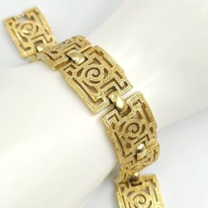 Braccialetto Trifari risalente al 1960 circa con decoro geometrico, realizzato in lega Trifanium color oro con lavorazione a cera persa e dettagli lucidi - VINTAGE AMORE MIO Braccialetto Trifari risalente al 1960 circa con decoro geometrico, realizzato in lega Trifanium color oro con lavorazione a cera persa e dettagli lucidi - VINTAGE AMORE MIO