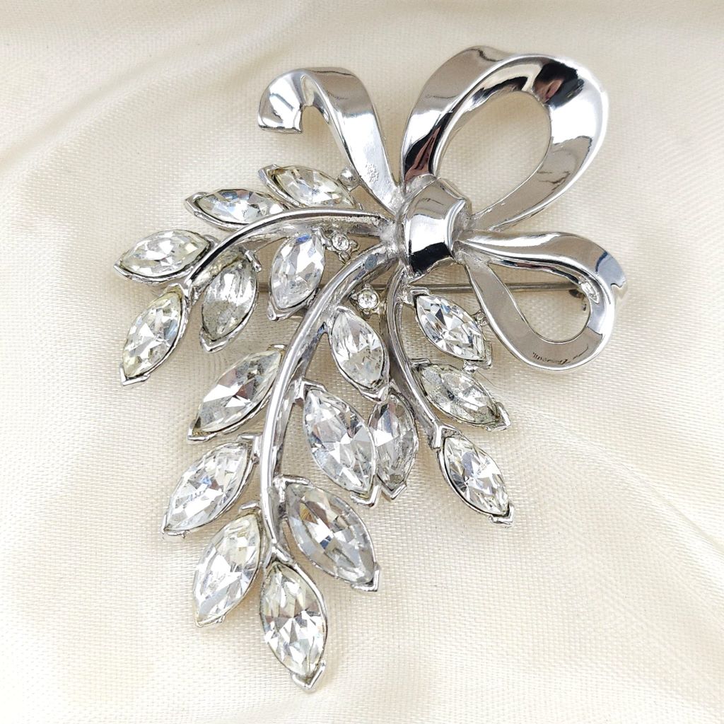 Spilla Trifari anni '50 a forma di raffinato fiocco in lega Trifanium color platino, con cristalli diamante taglio navette - VINTAGE AMORE MIO Spilla Trifari anni '50 a forma di raffinato fiocco in lega Trifanium color platino, con cristalli diamante taglio navette - VINTAGE AMORE MIO