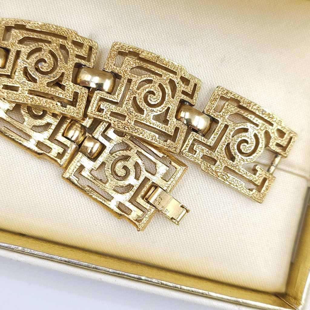 Braccialetto Trifari risalente al 1960 circa con decoro geometrico, realizzato in lega Trifanium color oro con lavorazione a cera persa e dettagli lucidi - VINTAGE AMORE MIO Braccialetto Trifari risalente al 1960 circa con decoro geometrico, realizzato in lega Trifanium color oro con lavorazione a cera persa e dettagli lucidi - VINTAGE AMORE MIO