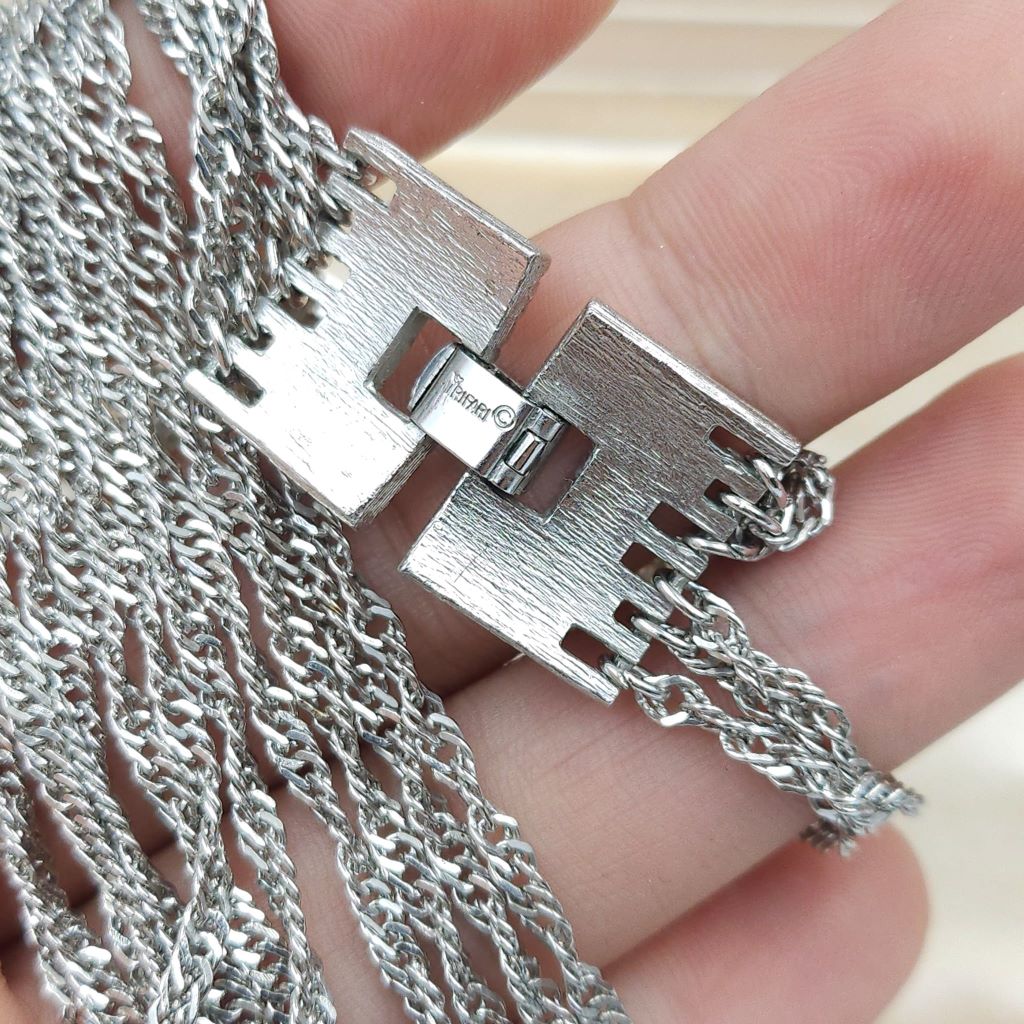 Collana firmata Trifari risalente alla seconda metà degli anni '50, realizzata in lega Trifanium color argento, con sei catene a torchon di lunghezza gradata e chiusura di ispirazione decò - VINTAGE AMORE MIO Collana firmata Trifari risalente alla seconda metà degli anni '50, realizzata in lega Trifanium color argento, con sei catene a torchon di lunghezza gradata e chiusura di ispirazione decò - VINTAGE AMORE MIO