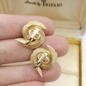 Orecchini a clip Trifari risalenti al 1960 circa, realizzati in lega Trifanium color oro satinato con piccoli dettagli lucidi con perla centrale - VINTAGE AMORE MIO Orecchini a clip Trifari risalenti al 1960 circa, realizzati in lega Trifanium color oro satinato con piccoli dettagli lucidi con perla centrale - VINTAGE AMORE MIO