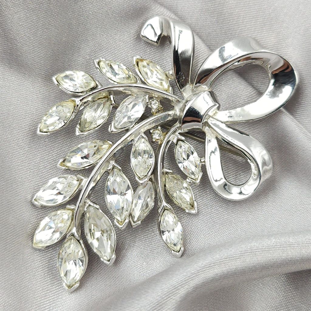 Spilla Trifari anni '50 a forma di raffinato fiocco in lega Trifanium color platino, con cristalli diamante taglio navette - VINTAGE AMORE MIO Spilla Trifari anni '50 a forma di raffinato fiocco in lega Trifanium color platino, con cristalli diamante taglio navette - VINTAGE AMORE MIO