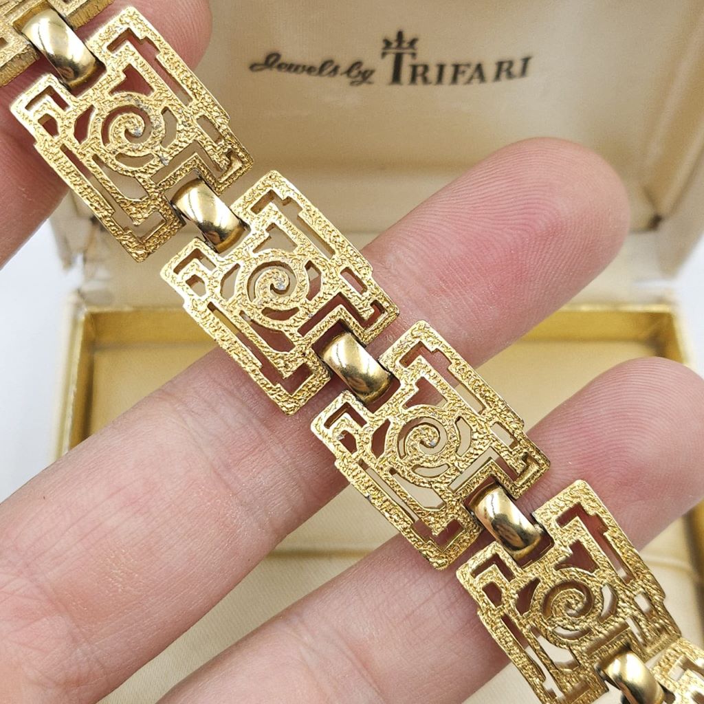 Braccialetto Trifari risalente al 1960 circa con decoro geometrico, realizzato in lega Trifanium color oro con lavorazione a cera persa e dettagli lucidi - VINTAGE AMORE MIO Braccialetto Trifari risalente al 1960 circa con decoro geometrico, realizzato in lega Trifanium color oro con lavorazione a cera persa e dettagli lucidi - VINTAGE AMORE MIO